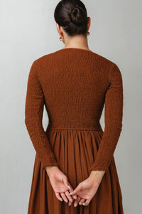 Brown textured linen dress worn by a person on a plain background