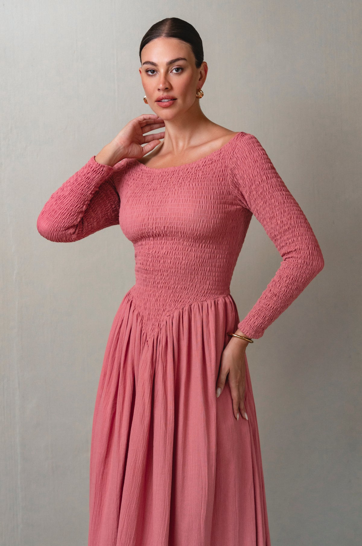 Woman wearing a pink dress against a plain background
