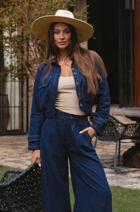 Woman wearing a blue denim outfit with a beige hat outdoors - cottage core style