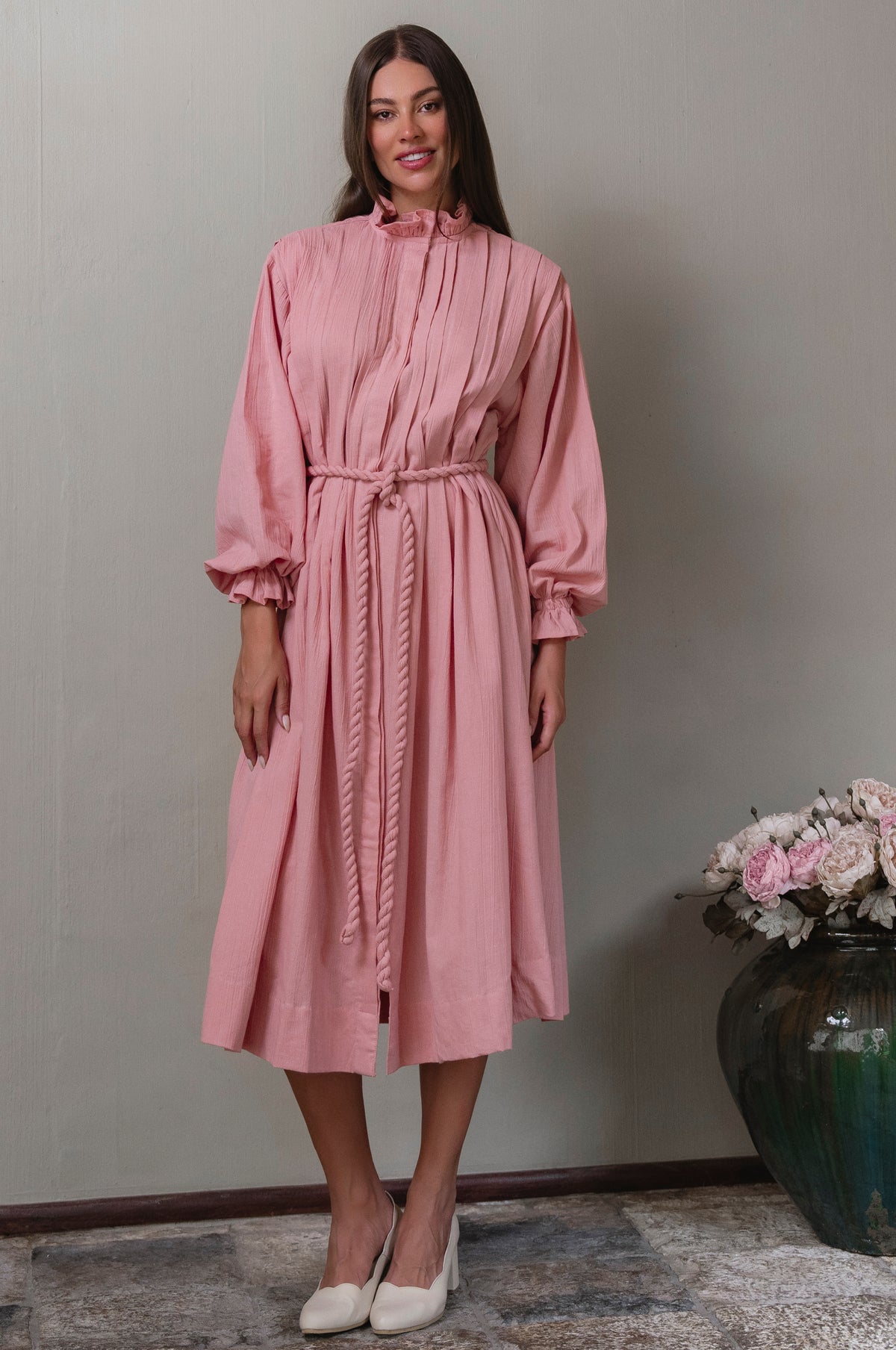 Woman wearing a pink linen dress with long sleeves