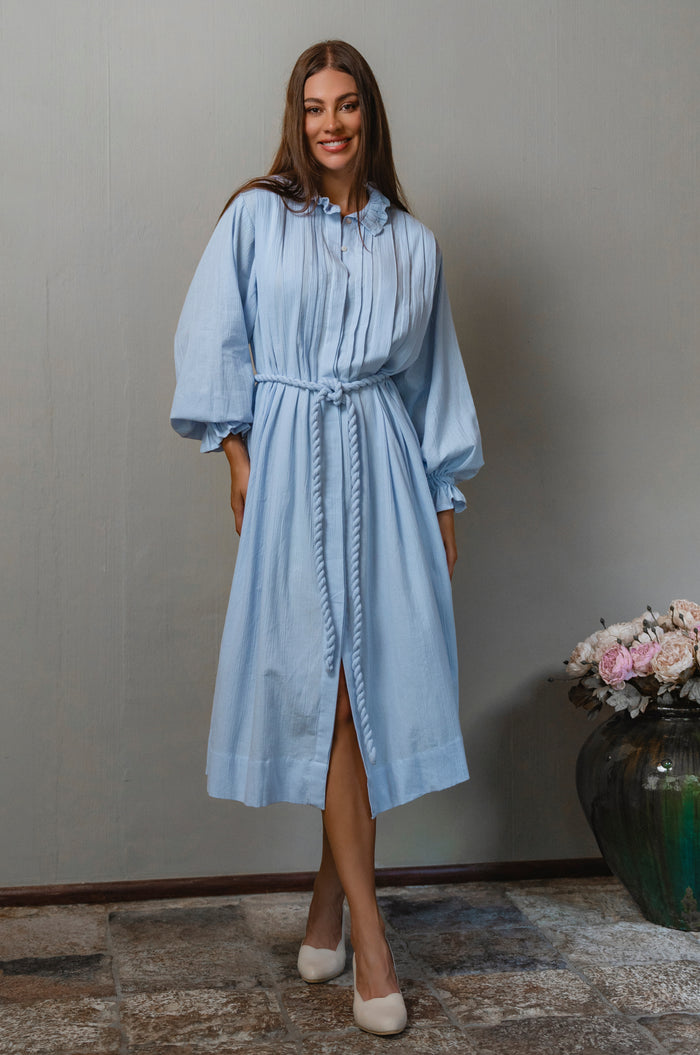 Woman wearing a light blue linen long sleeve dress 